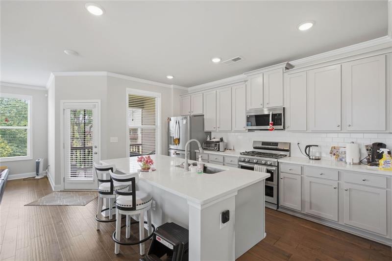 Kitchen with white cabinetry, island and stainless steel appliances